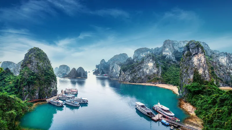 Những đảo đá vôi nhô lên quanh làn nước xanh ngọc cùng các thuyền du lịch ở vịnh Hạ Long.