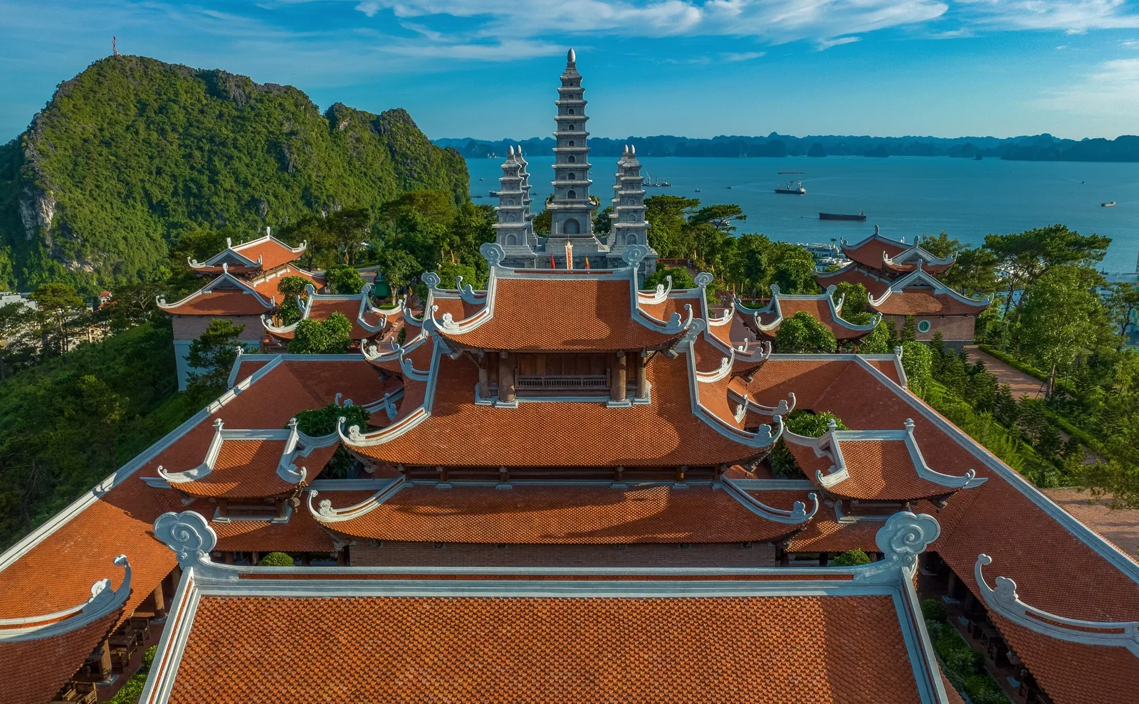 Toàn cảnh trên cao chùa Bảo Hải Linh Thông với mái ngói đỏ và tháp nhiều tầng hướng ra vịnh Hạ Long.