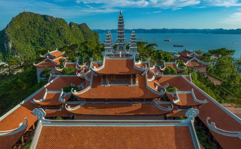 Toàn cảnh trên cao chùa Bảo Hải Linh Thông với mái ngói đỏ và tháp nhiều tầng hướng ra vịnh Hạ Long.