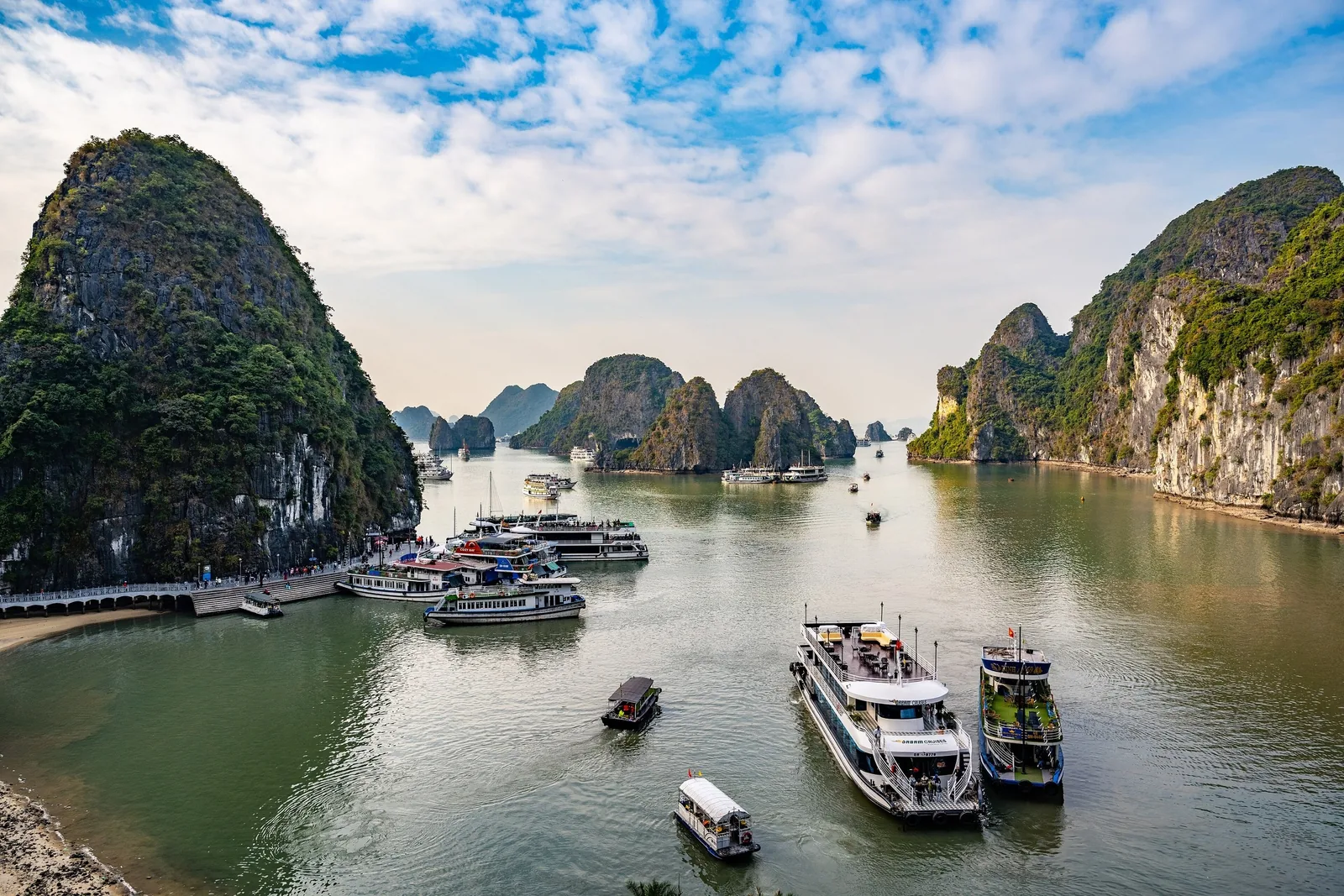 Những chiếc tàu du lịch len lỏi giữa các đảo đá vôi gần hang Sửng Sốt ở vịnh Hạ Long.