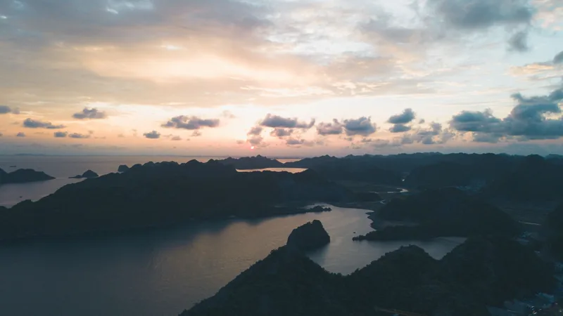 Toàn cảnh trên cao vịnh Hạ Long với những đảo đá vôi in bóng dưới bầu trời hoàng hôn rực rỡ