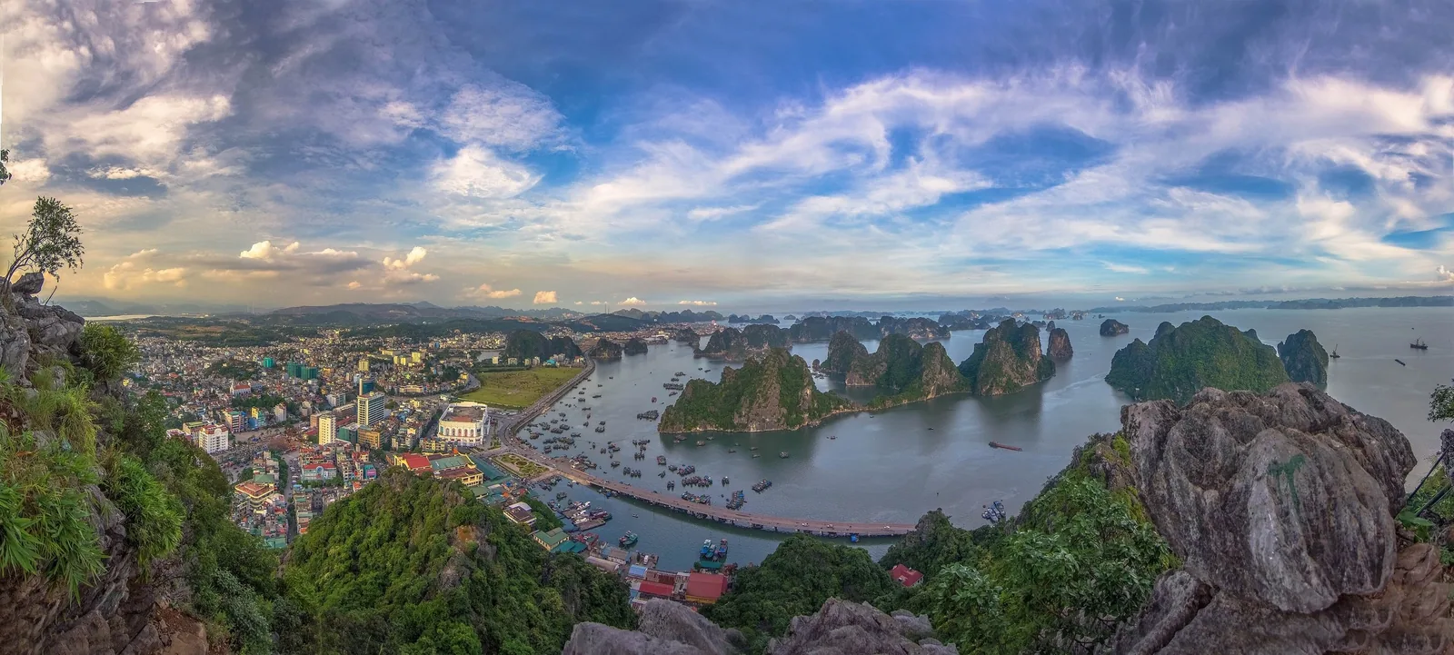 Toàn cảnh từ đỉnh núi nhìn xuống thành phố Hạ Long và các đảo đá vôi của vịnh Bái Tử Long lúc hoàng hôn.